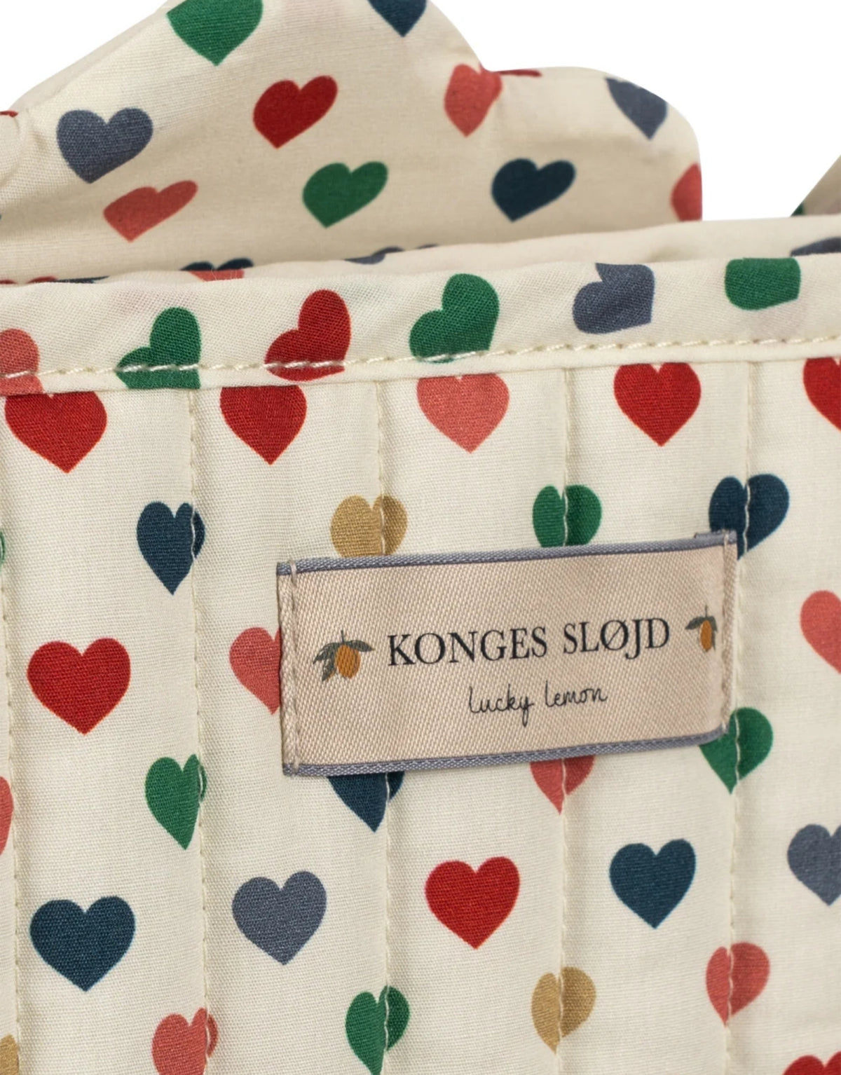  Puppenwagen Coeur Coloré von Konges Sløjd mit Herzmuster, Wagentasche, gepolsterten Griffen und Doppelrädern.