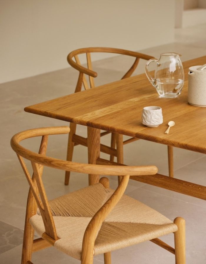 Carl Hansen Wishbone Chair CH24 in Eiche geölt, mit Sitzfläche aus Naturkordel an einem Tisch