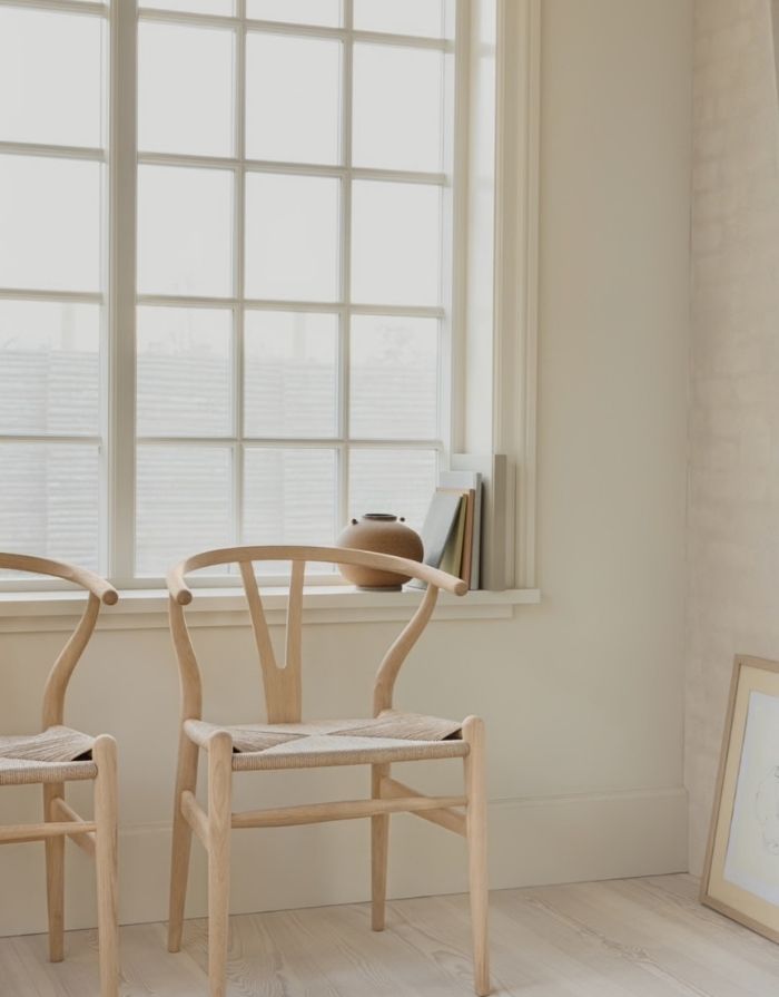 Carl Hansen Wishbone Chair CH24 in Eiche geseift mit Sitzfläche aus Naturkordel vor einem Fenster