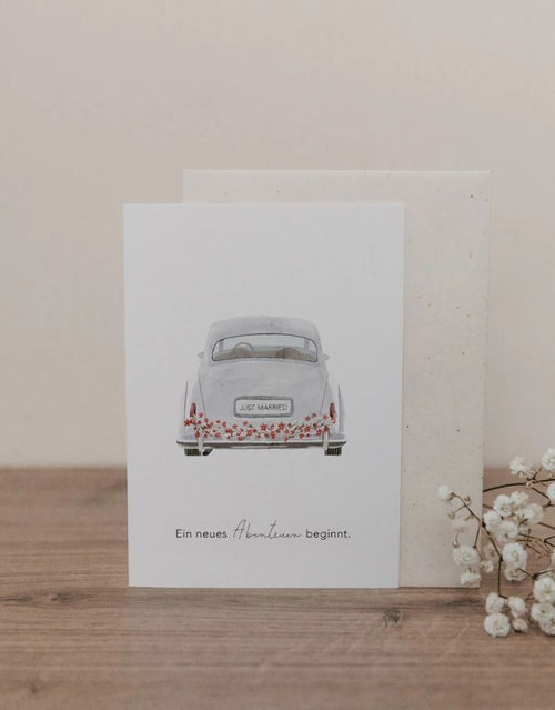 Klappkarte mit Umschlag von Eulenschnitt mit einem Bild von einem VW Käfer und der Aufschrift Ein neues Abenteuer beginnt