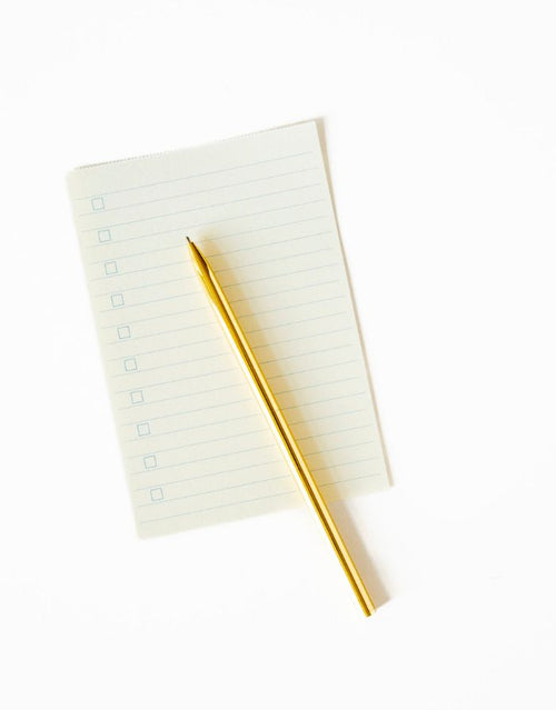 Goldfarbener Kugelschreiber von A-Journal in hochwertiger Geschenkbox für Notizen, Journaling und den Alltag auf Papier drapiert