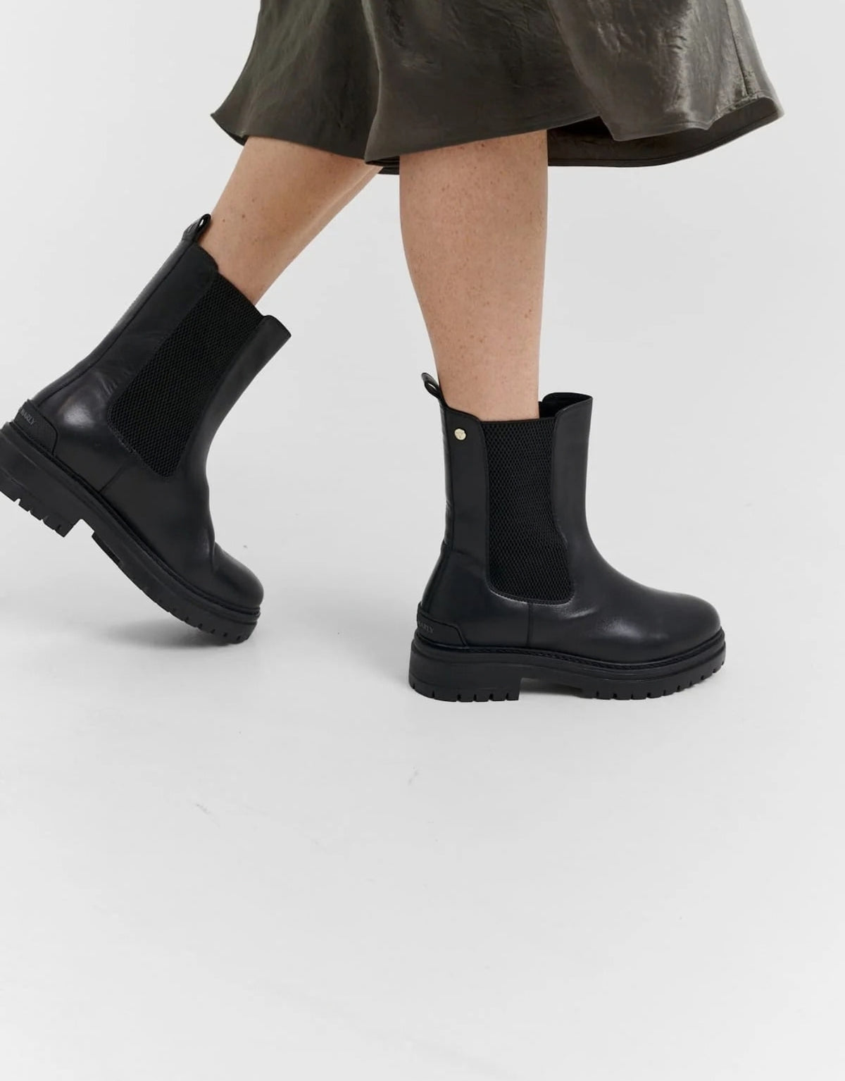 Hey Marly Chelsea Boot City Stroll in Schwarz aus Leder mit elastischem Einsatz, profiliertem Blockabsatz und dezenten goldfarbenen Details am Model von der Seite in Bewegung