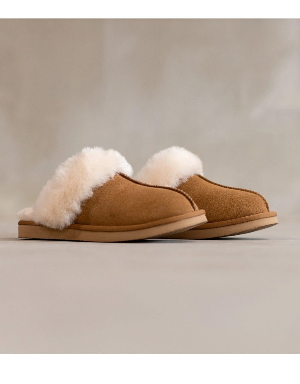 Lumi Slipper aus echtem Wildleder mit weichem Schafwollfutter, sichtbarem Wollkragen und robuster Gummisohle als Freisteller von der Seite 