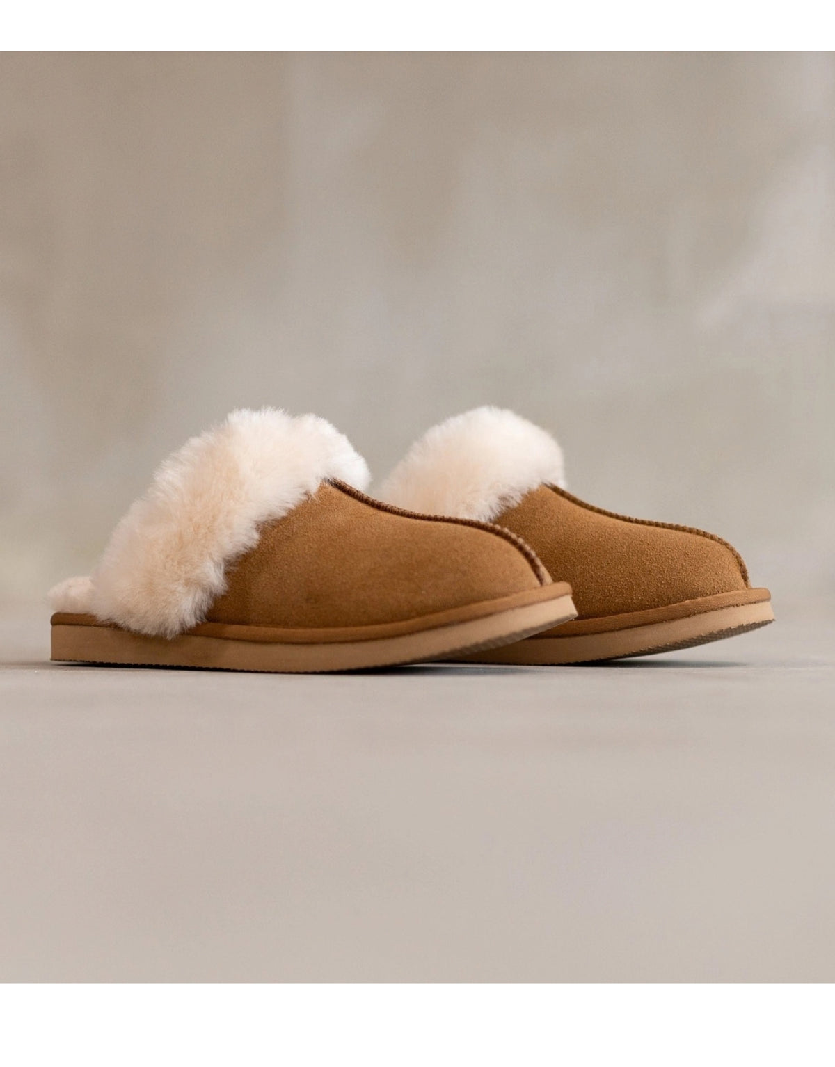 Lumi Slipper aus echtem Wildleder mit weichem Schafwollfutter, sichtbarem Wollkragen und robuster Gummisohle als Freisteller von der Seite 