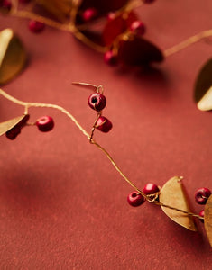 House Doctor Girlande Leafi Messing – handgefertigte Messinggirlande mit goldenen Blättern und roten Mangoholzperlen.