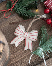 Laden Sie das Bild in den Galerie-Viewer, Hängedekoration Schleife aus Steingut in Rot-Weiß von Det Gamle Apotek – klassisch dänisches Weihnachtsornament.
