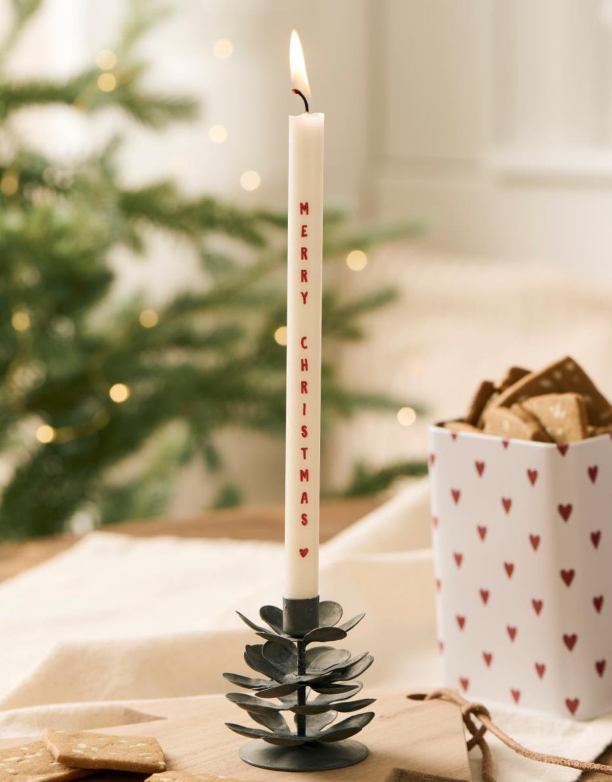 Schlanke weiße Merry Christmas  Stabkerze von Ib Laursen mit rotem Weihnachtsschriftzug und kleinem Herz, 20 cm hoch und 1,3 cm im Durchmesser.
