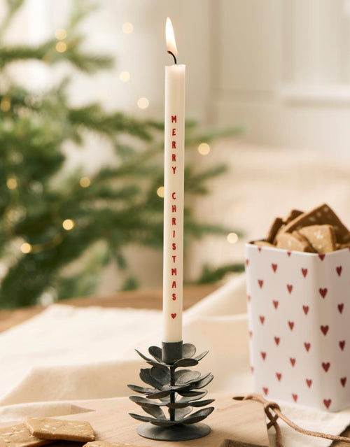 Schlanke weiße Merry Christmas  Stabkerze von Ib Laursen mit rotem Weihnachtsschriftzug und kleinem Herz, 20 cm hoch und 1,3 cm im Durchmesser.