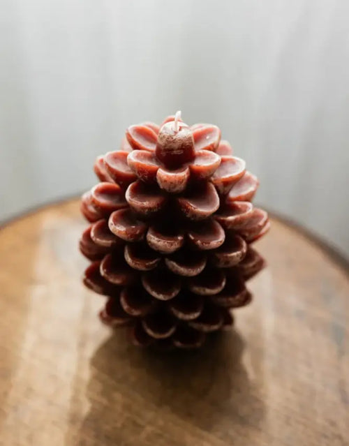 Dekokerze Kiefernzapfen von HOMLA in Braun, 11 cm hohe Weihnachtskerze aus Paraffin in naturgetreuer Tannenzapfenform mit detailreicher Oberfläche und rustikalem Design.