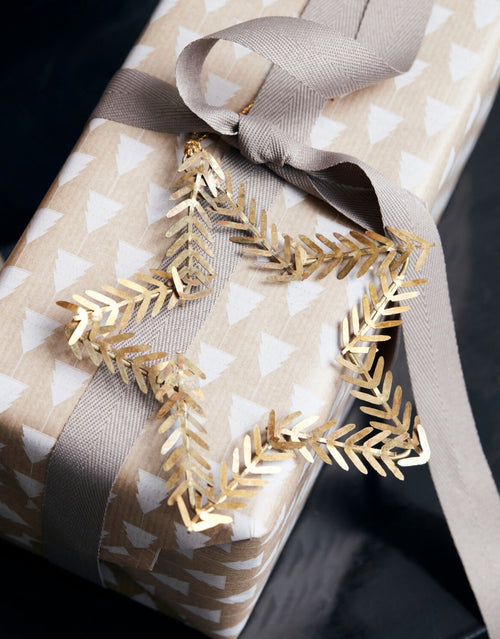 Sternförmiger Weihnachtsschmuck von House Doctor in Messingfarben auf Geschenk
