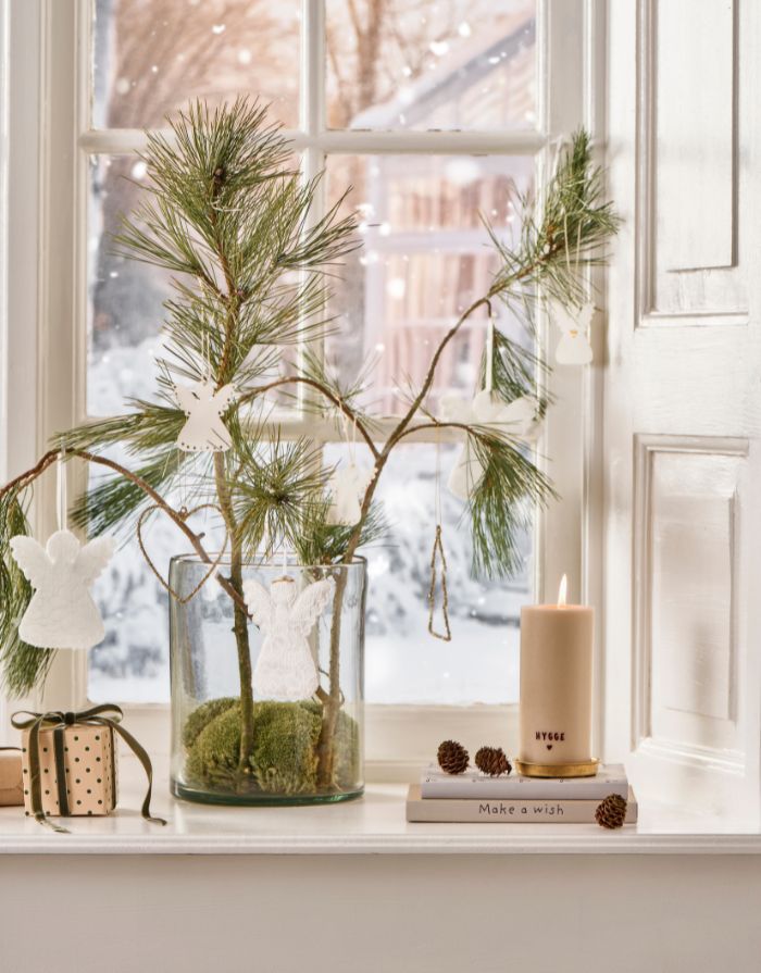 Rustikale weiße Stumpenkerze mit braunem „Hygge“-Schriftzug.