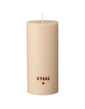 Laden Sie das Bild in den Galerie-Viewer, Rustikale weiße Stumpenkerze mit braunem „Hygge“-Schriftzug.
