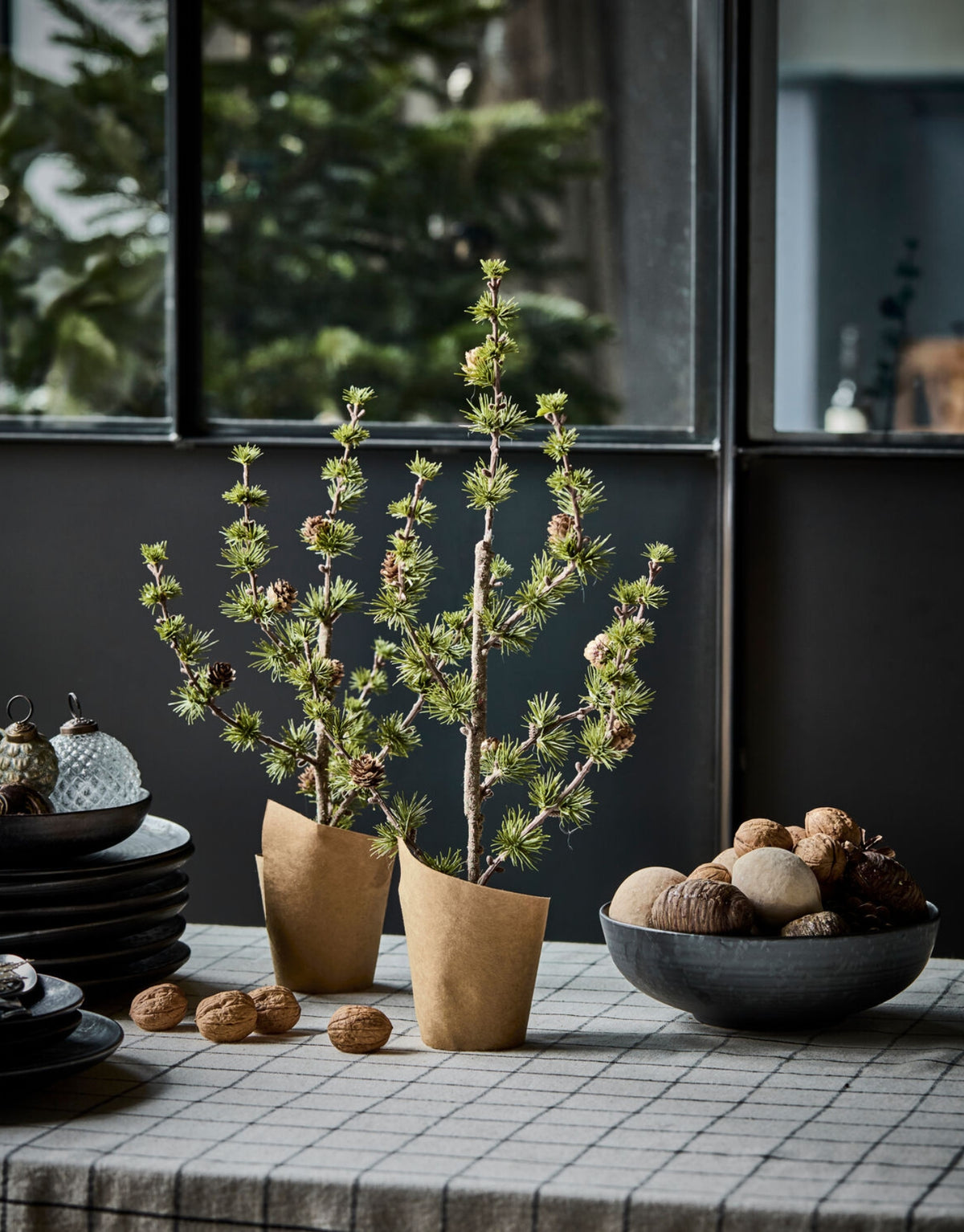 Grüner künstlicher Weihnachtsbaum Stay von House Doctor in natürlicher Zedernoptik mit feinen Zweigen und kleinen Zapfen, 40 cm hoch auf einem Tisch