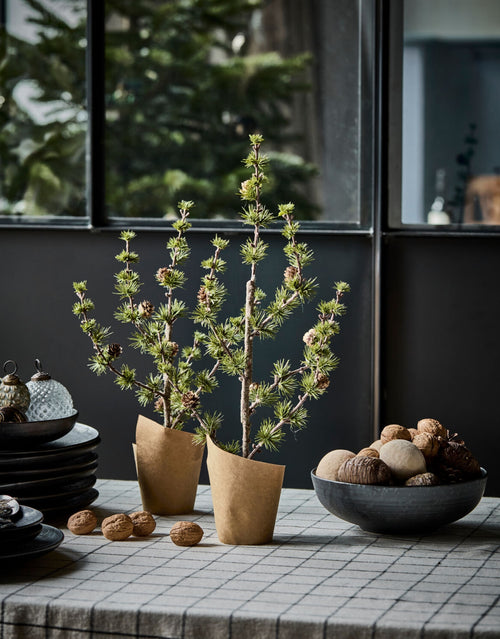 Grüner künstlicher Weihnachtsbaum Stay von House Doctor in natürlicher Zedernoptik mit feinen Zweigen und kleinen Zapfen, 40 cm hoch auf einem Tisch