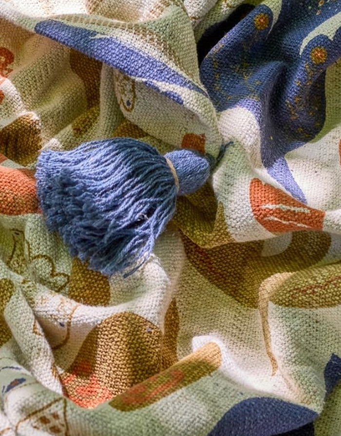 Anniversary Decke von Bloomingville in Beige mit botanischen und floralen Motiven in Blau und Braun sowie großen blauen Quasten, 160 × 130 cm im Detail