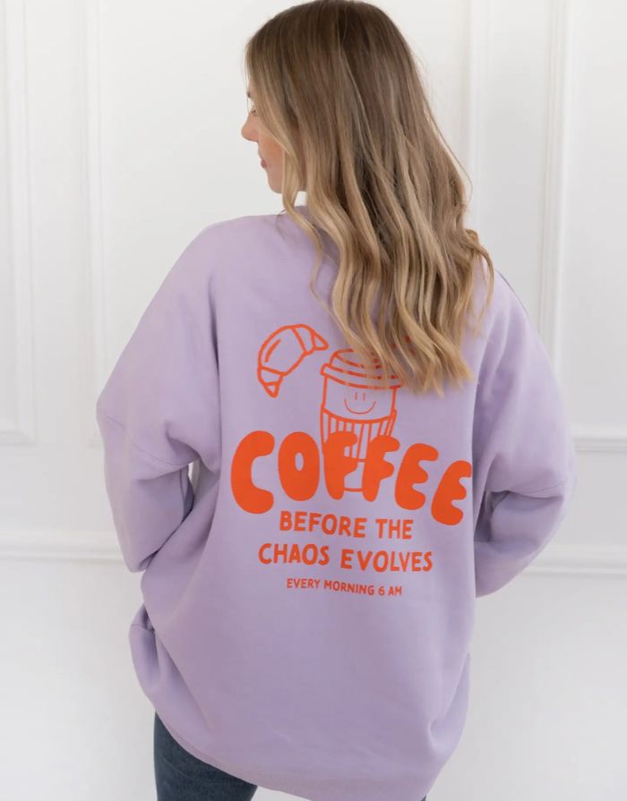 Fliederfarbenes Oversized Sweatshirt von Liliput mit „6am“-Print auf der Brust und großem Rückenschriftzug „Coffee before the Chaos evolves“ – gemütlich und stylisch für den Eltern-Alltag.
