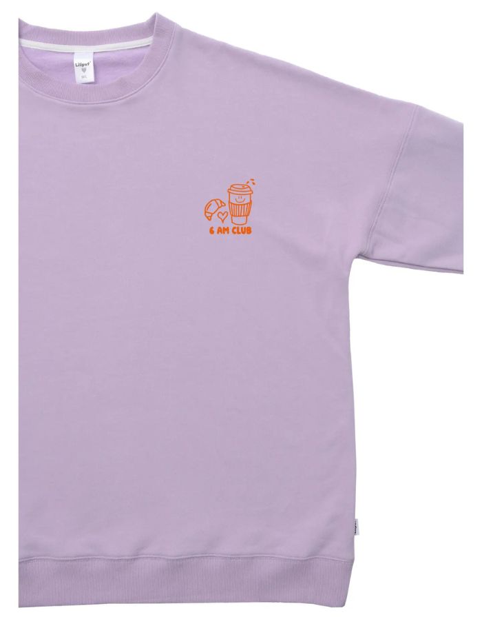 Fliederfarbenes Oversized Sweatshirt von Liliput mit „6am“-Print auf der Brust und großem Rückenschriftzug „Coffee before the Chaos evolves“ – gemütlich und stylisch für den Eltern-Alltag.